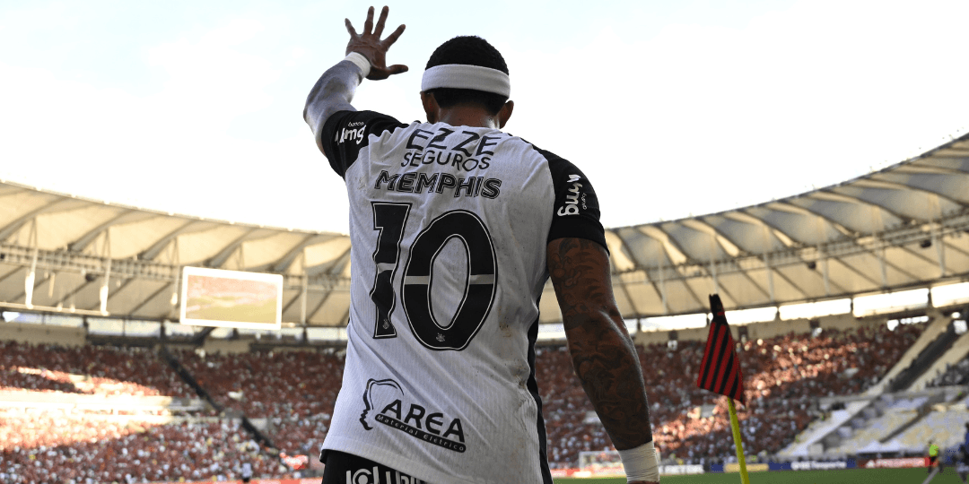 Jogador Memphis Depay, do Corinthians, aparece de costas levantando a mão para a torcida em estádio lotado durante partida, em imagem que ilustra discussões sobre o futuro do Memphis Depay no Corinthians.