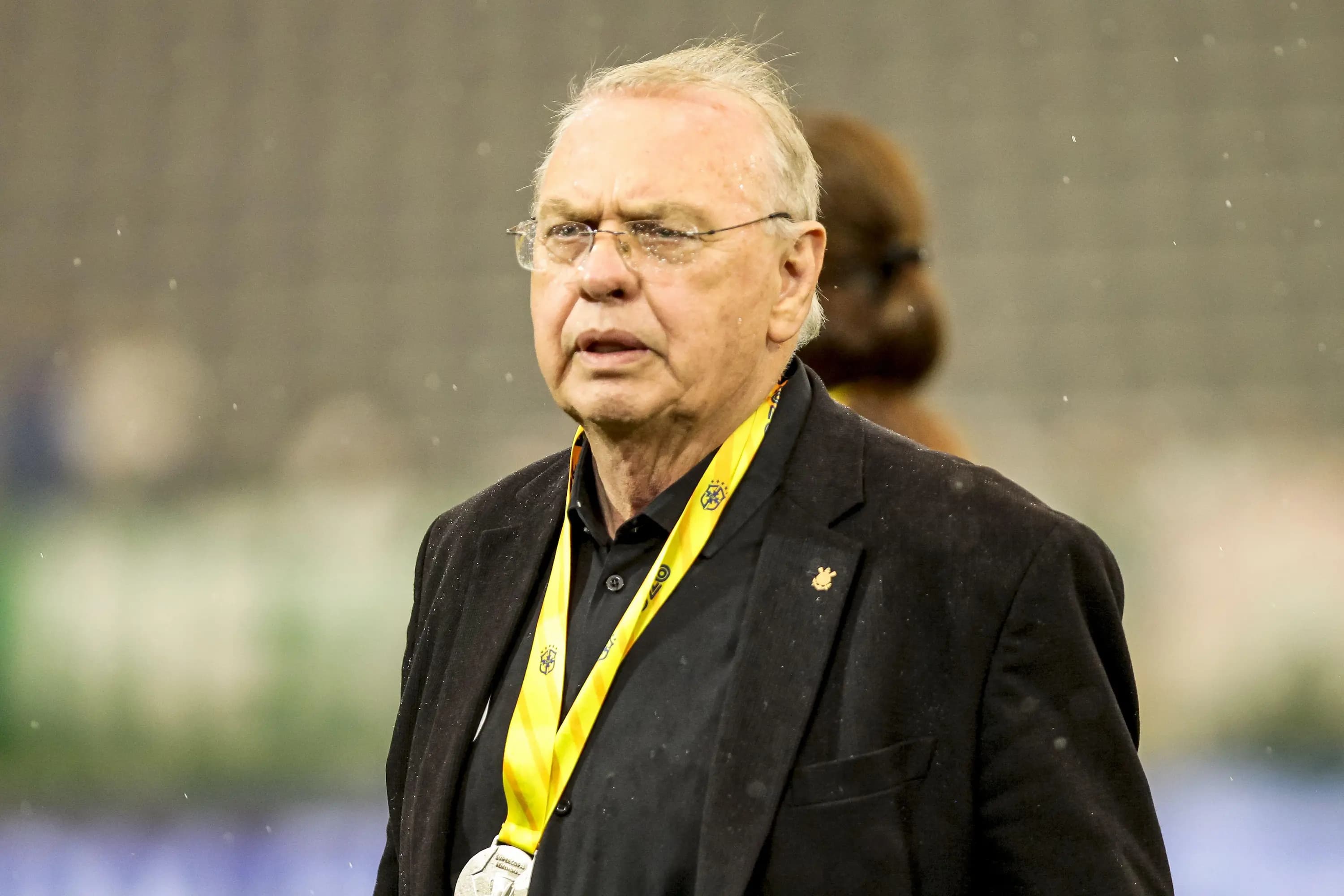 Osmar Stabile, presidente do Corinthians, observa jogo da Seleção Brasileira usando credencial amarela e terno preto